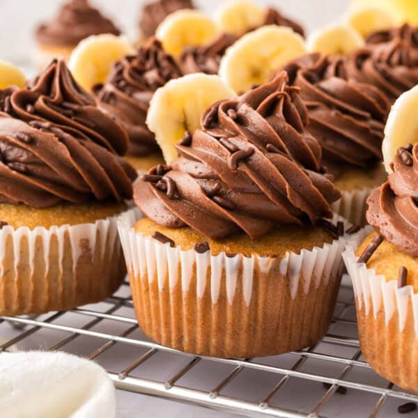 Banana cupcakes topped with chocolate frosting and banana slices.