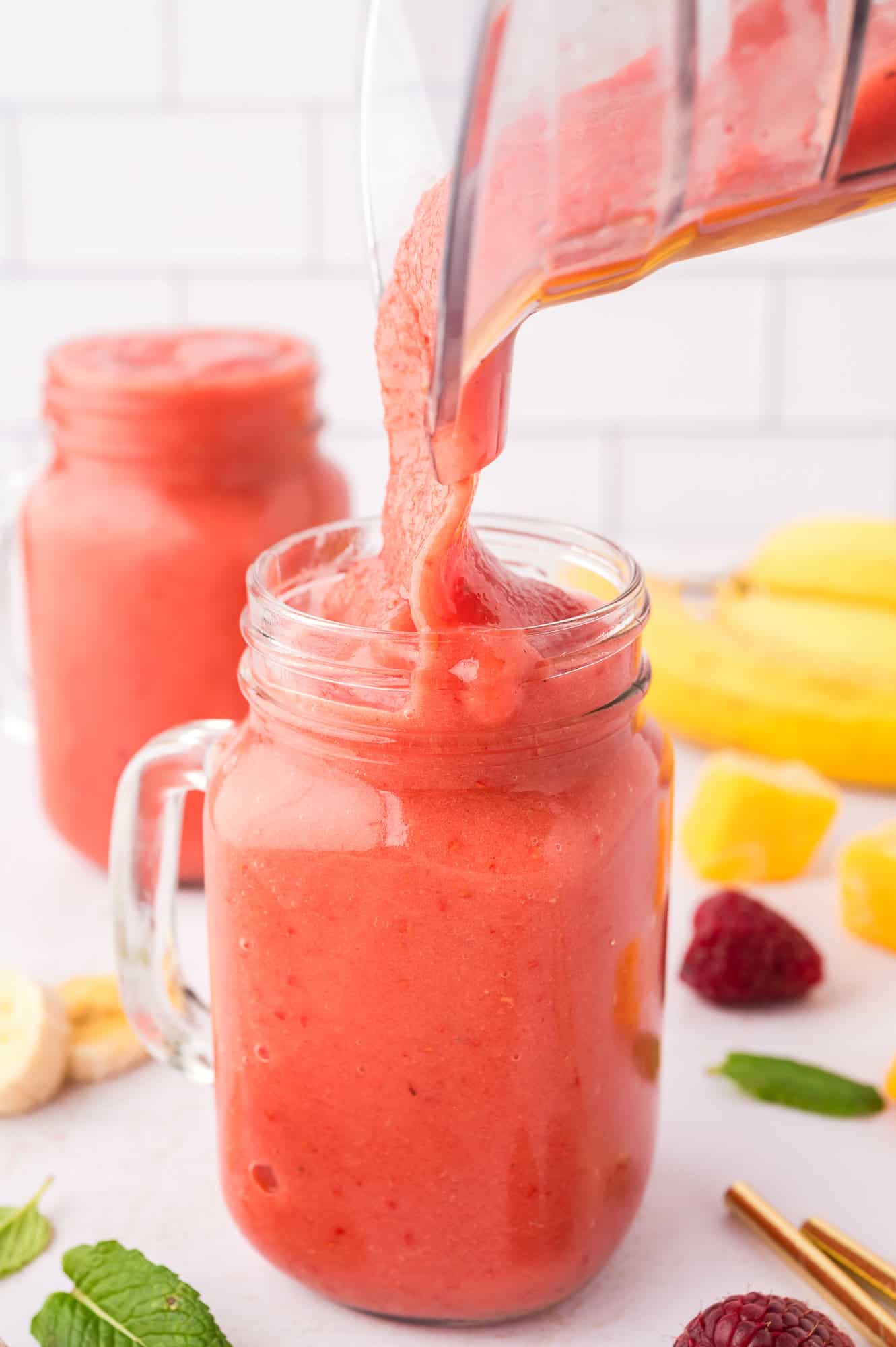 Smoothie being poured into a mason jar style glass.