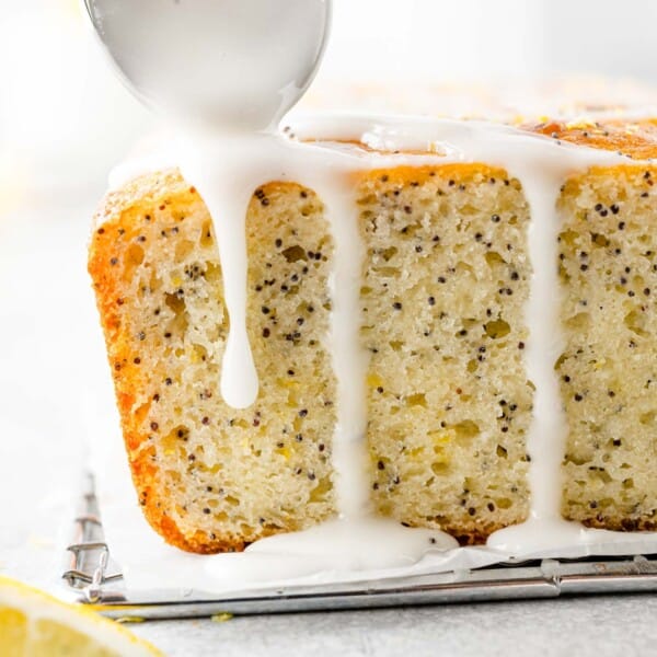 Glaze being added to lemon poppy seed bread.