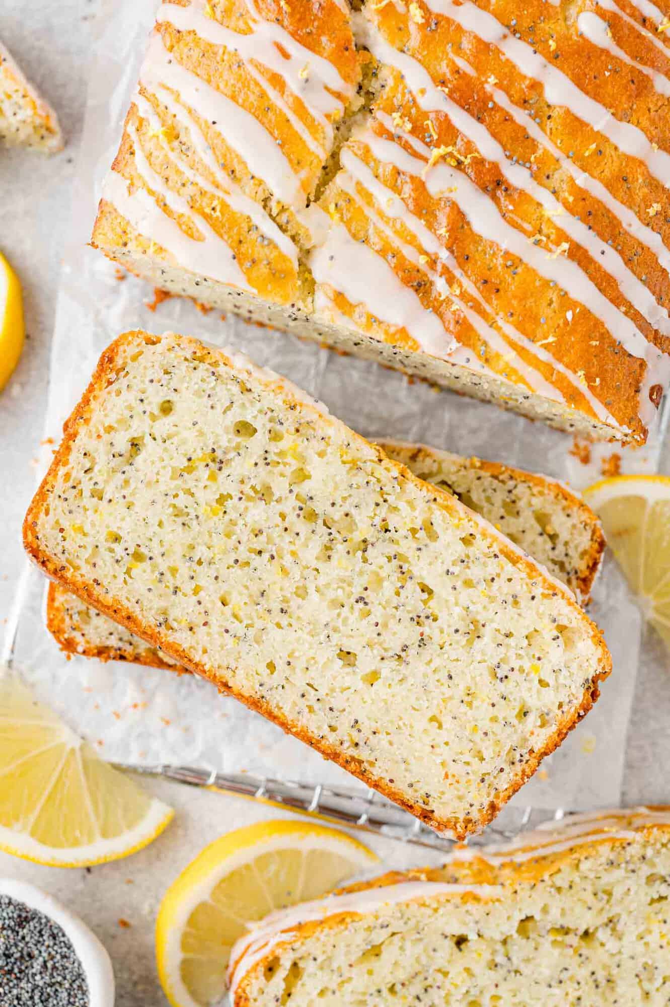 Lemon poppy seed bread with glaze, partially sliced.