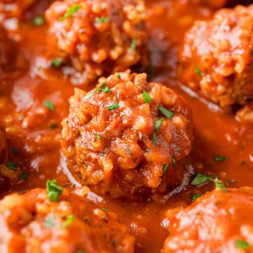 Porcupine meatballs in a rich tomato sauce, sprinkled with parsley.