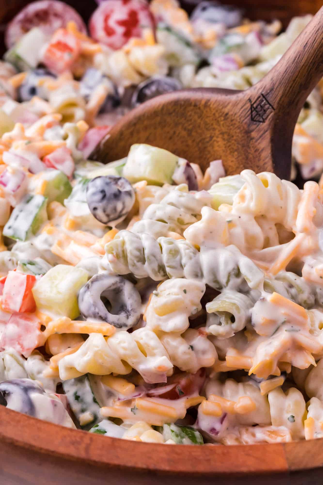 Ranch pasta salad, with a wooden serving spoon.