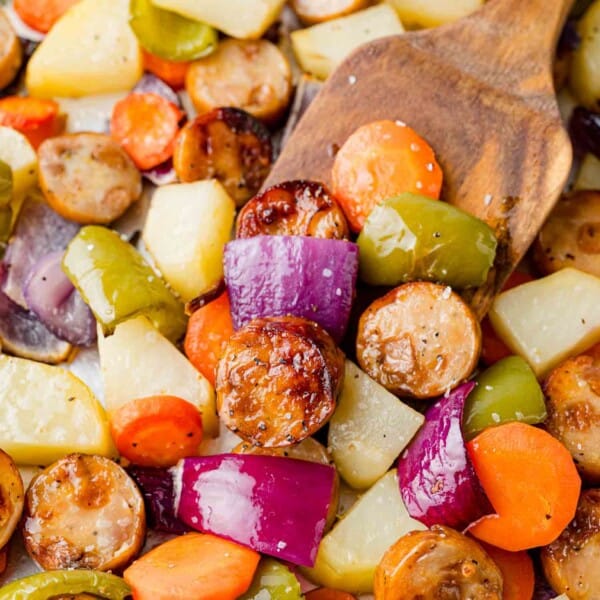 Sliced sausage with vegetable and potatoes on a sheet pan.