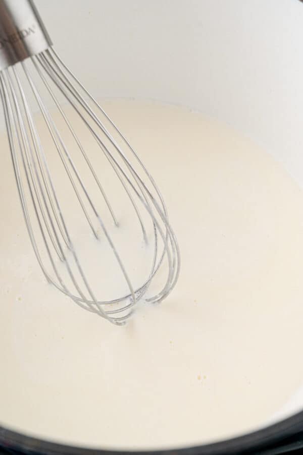 White sauce in pan, with whisk.