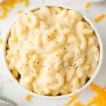 Overhead view of stovetop mac and cheese in a white bowl, sprinkled with pepper.