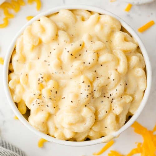 Overhead view of stovetop mac and cheese in a white bowl, sprinkled with pepper.