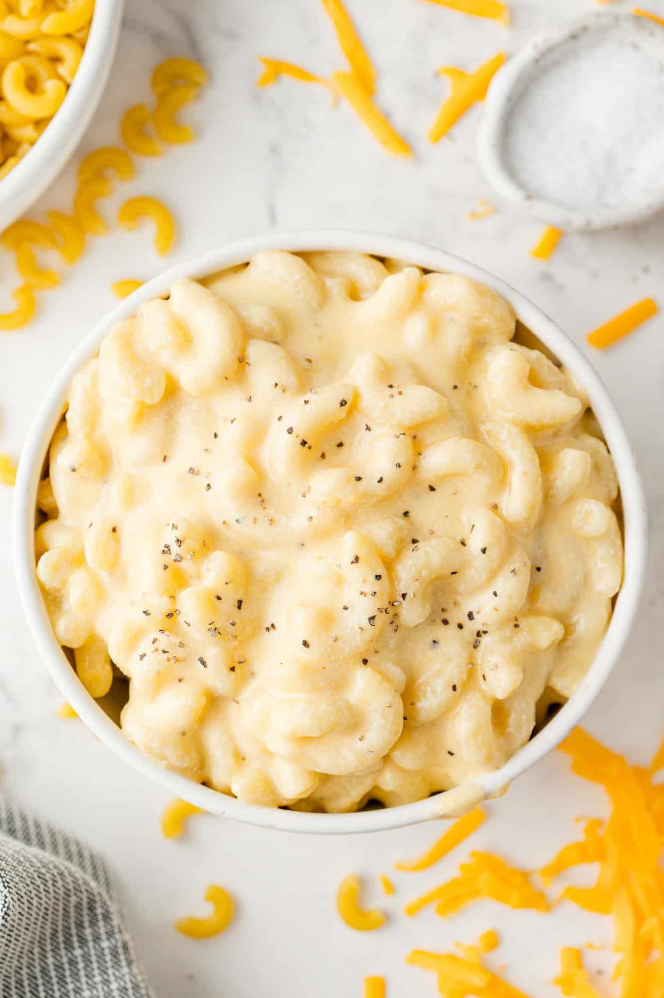 Creamy stovetop mac and cheese in a white bowl, sprinkle with black pepper.