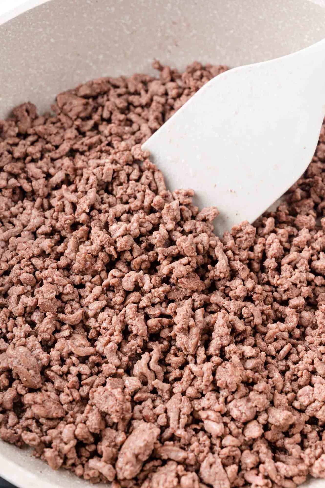 Ground beef being cooked in a frying pan.