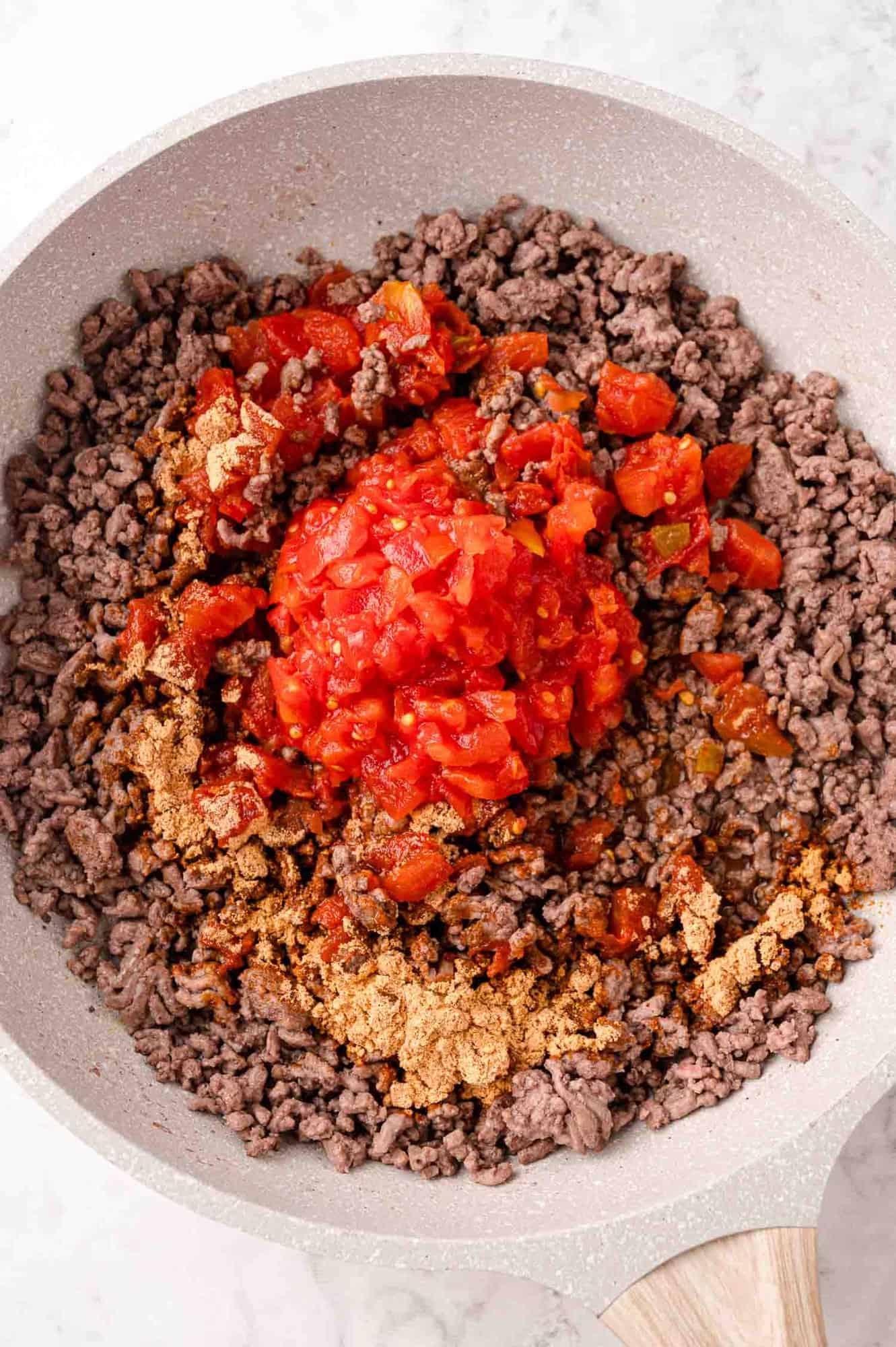 Tomatoes and taco seasoning added to meat mixture.