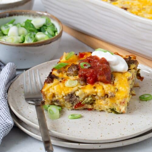 Slice of hash brown breakfast casserole topped with salsa and sour cream.