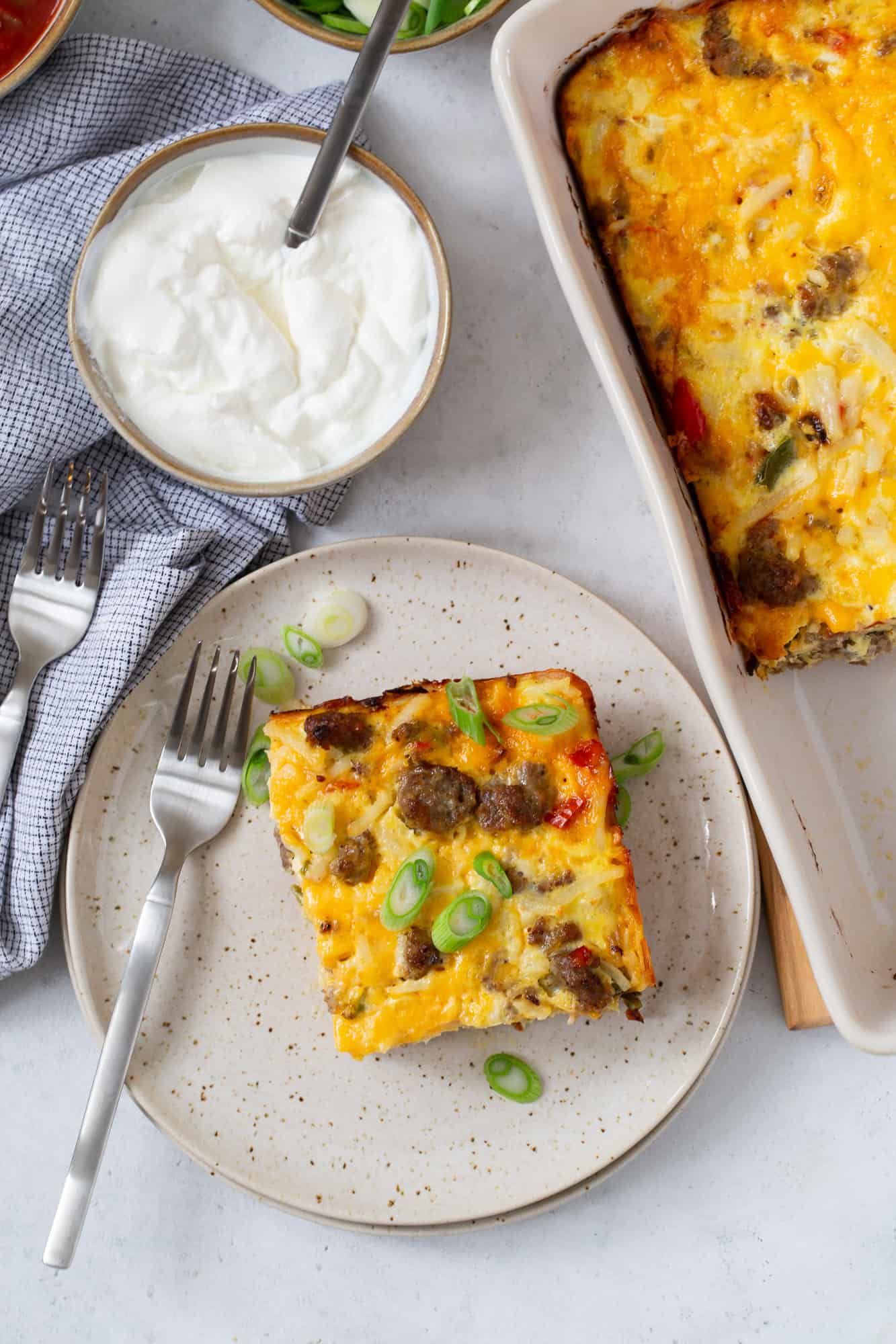 Overhead view of slice of breakfast casserole topped with sliced green onions.