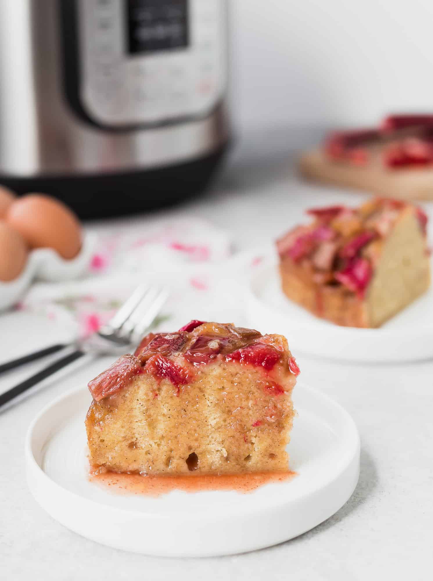 Slice of instant pot cake in front of another, and an instant pot.