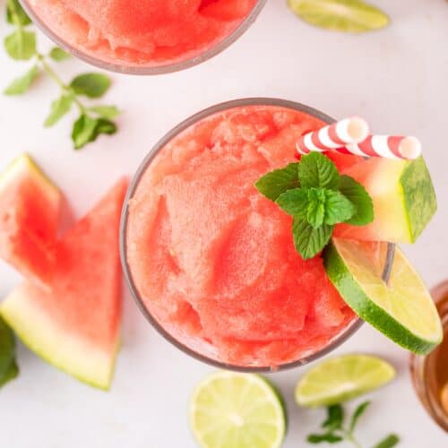 Overhead view of watermelon slushie garnished with lime and mint.