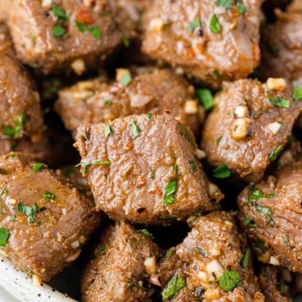 Close up of air fryer steak bites with garlic parsley butter.