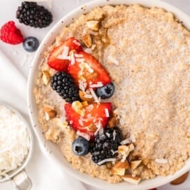 Bowl of breakfast quinoa topped with fresh berries and nuts.