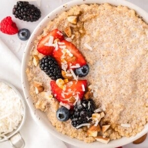 Bowl of breakfast quinoa topped with fresh berries and nuts.