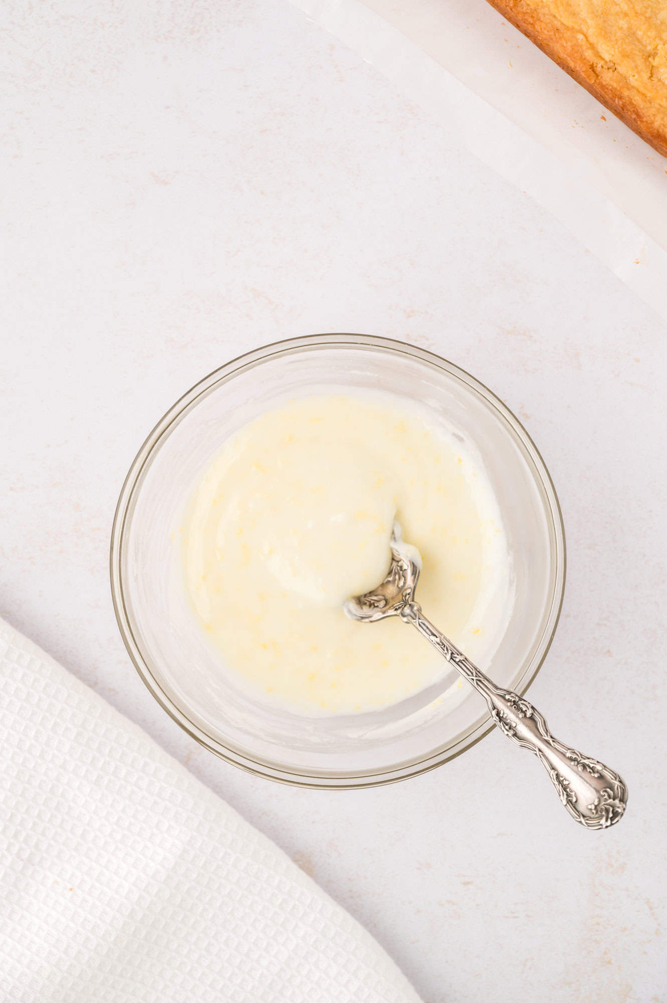 Lemon glaze in a small bowl with a spoon.