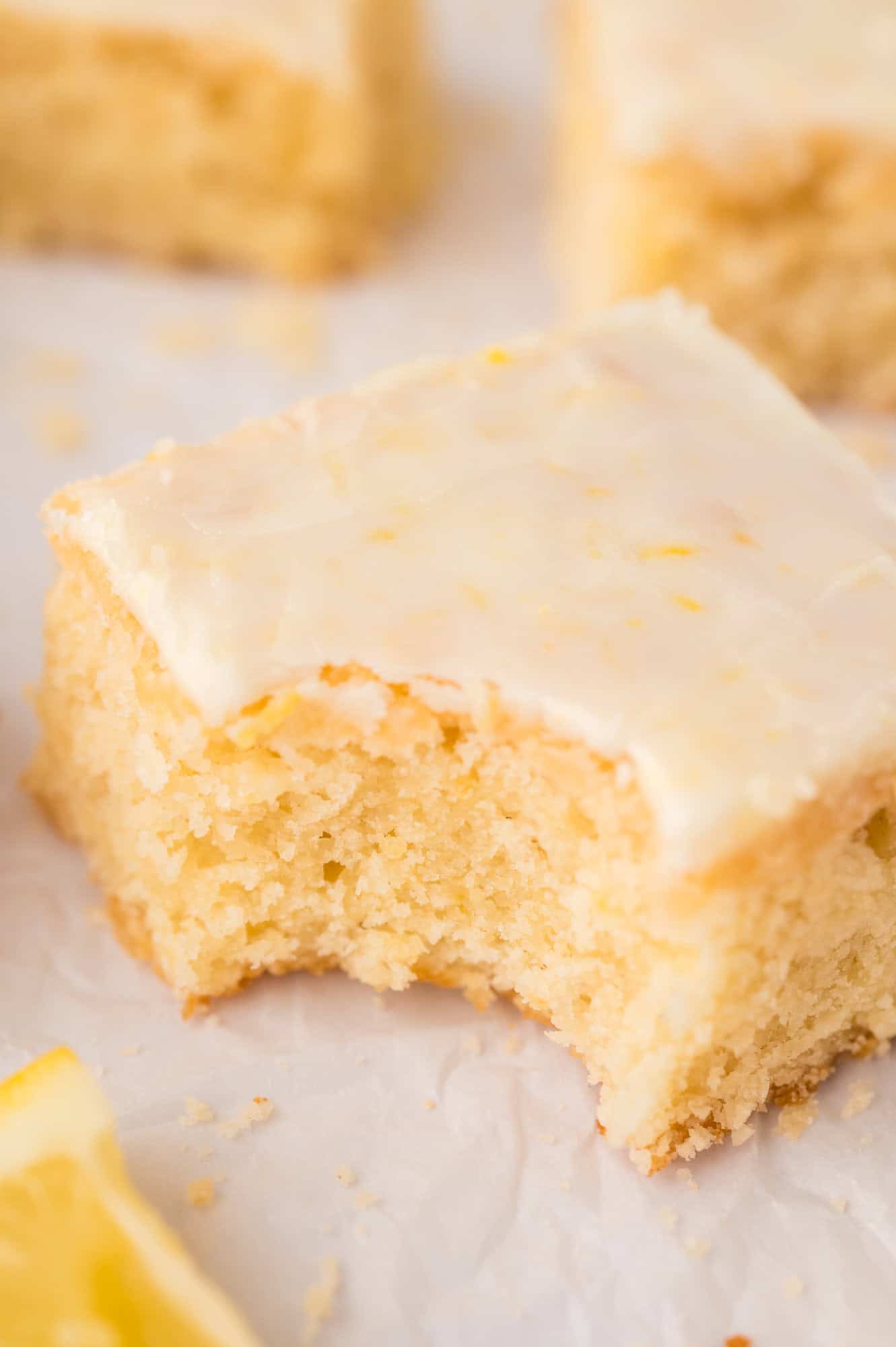 Close up image of lemon brownie with a large bite taken from it.