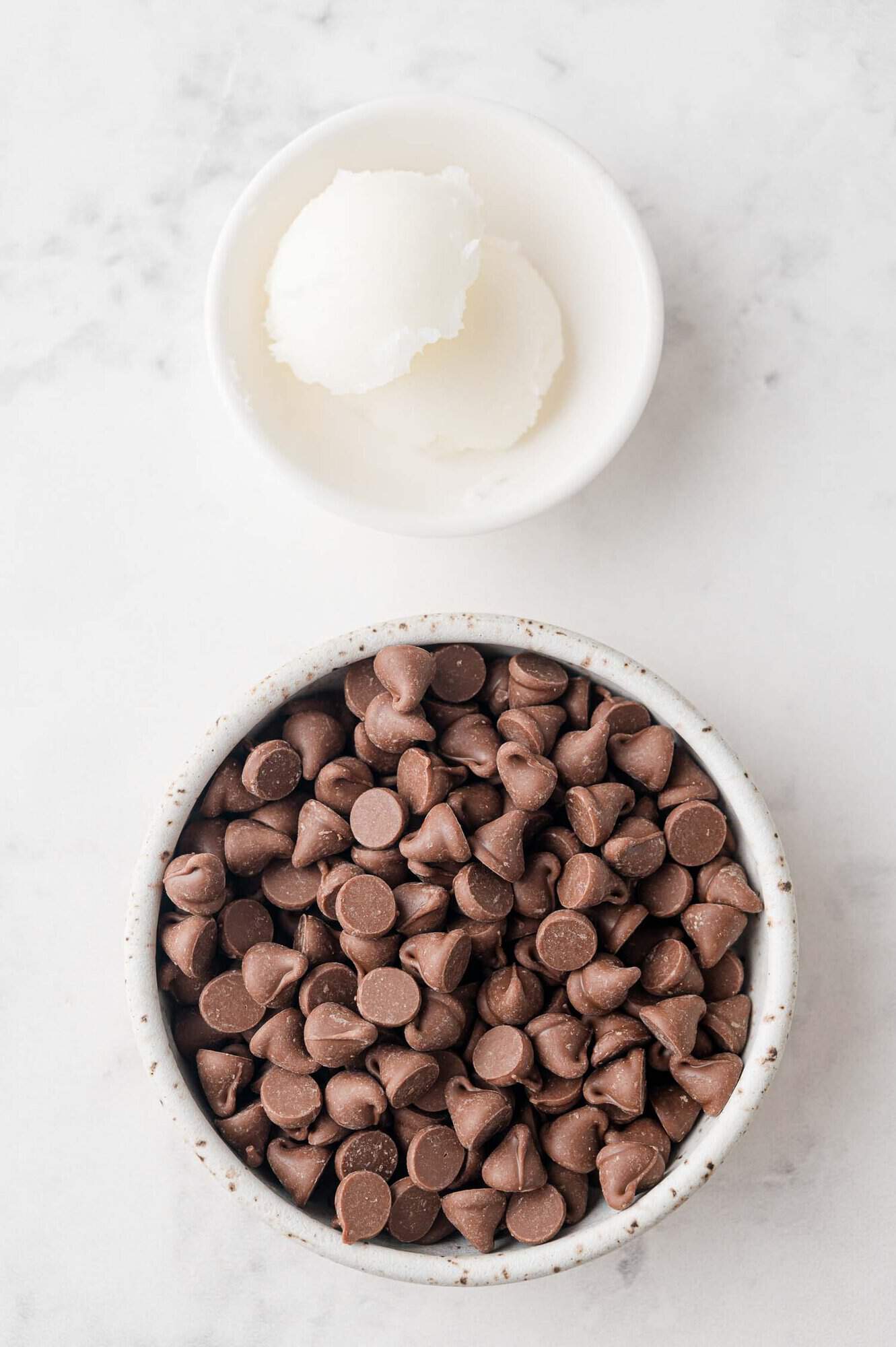 Overhead view of ingredients needed for recipe, chocolate chips and coconut oil.