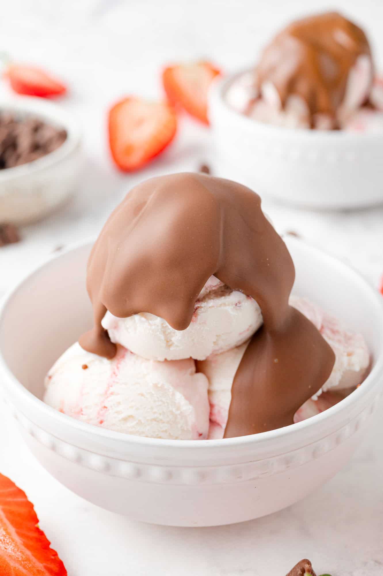 Chocolate magic shell on top of strawberry ice cream.