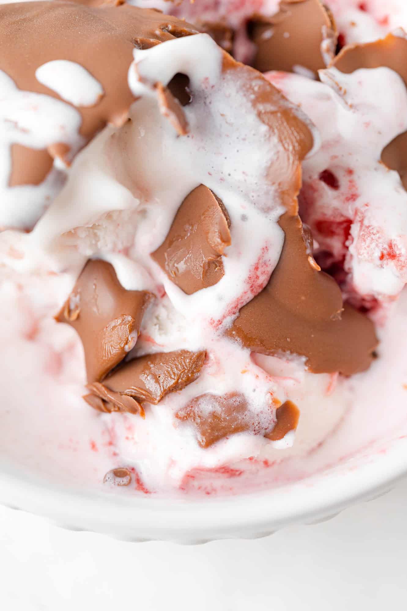 Magic shell on top of ice cream, cracked into many pieces.