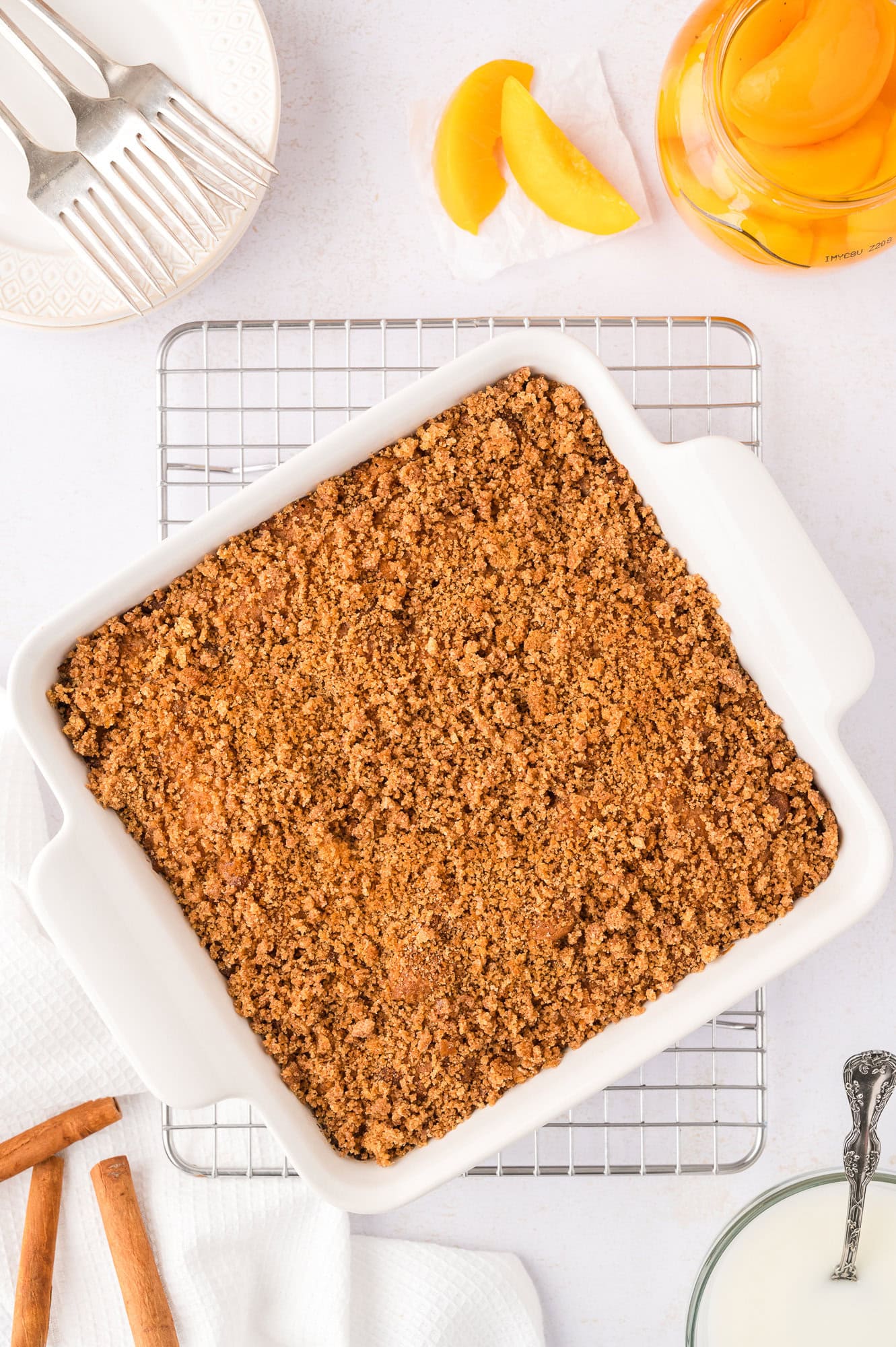 Baked coffee cake with streusel, still in baking dish, on cooling rack.