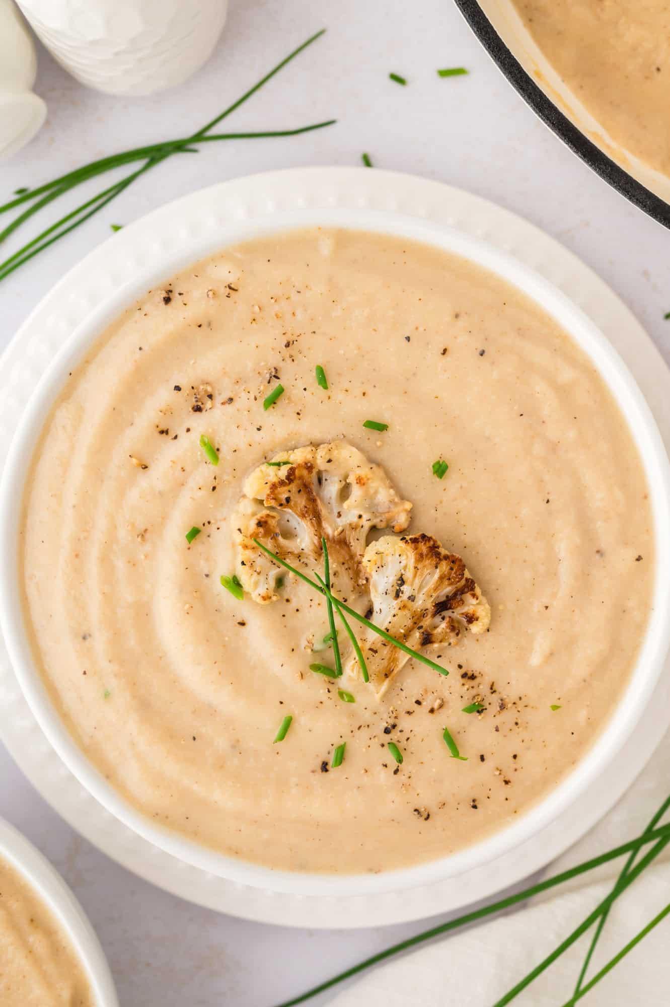Roasted cauliflower soup topped with roasted cauliflower and chives.