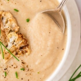 Roasted cauliflower soup topped with roasted cauliflower and chives.