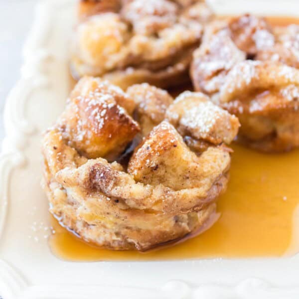 French toast muffins sprinkled with powdered sugar, in a pool of syrup.