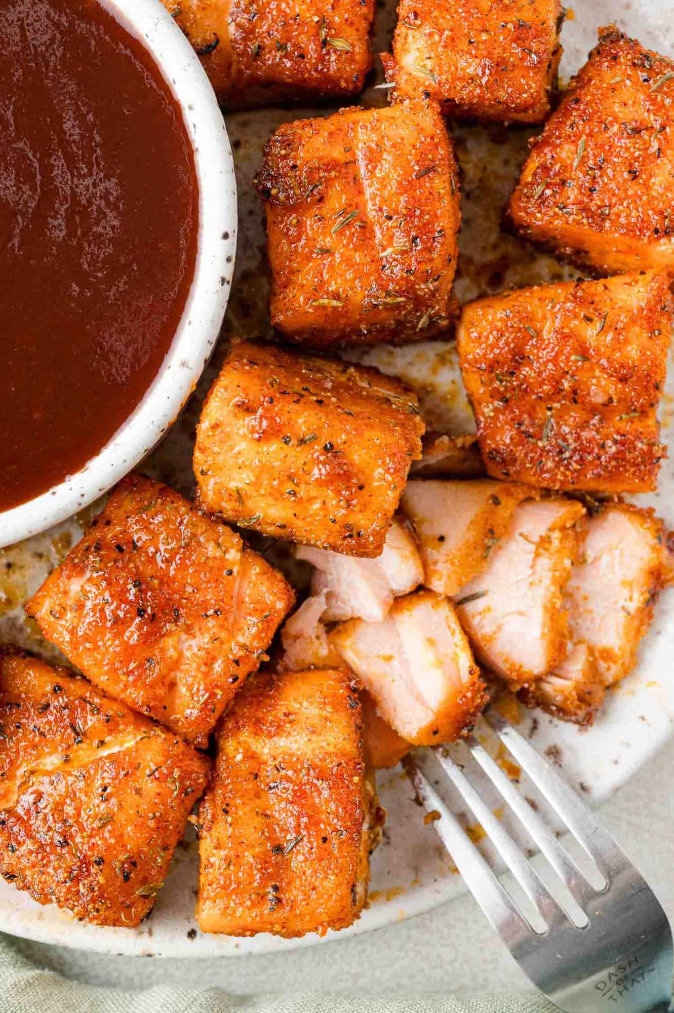 Air fryer salmon bites, one flaked to show texture.