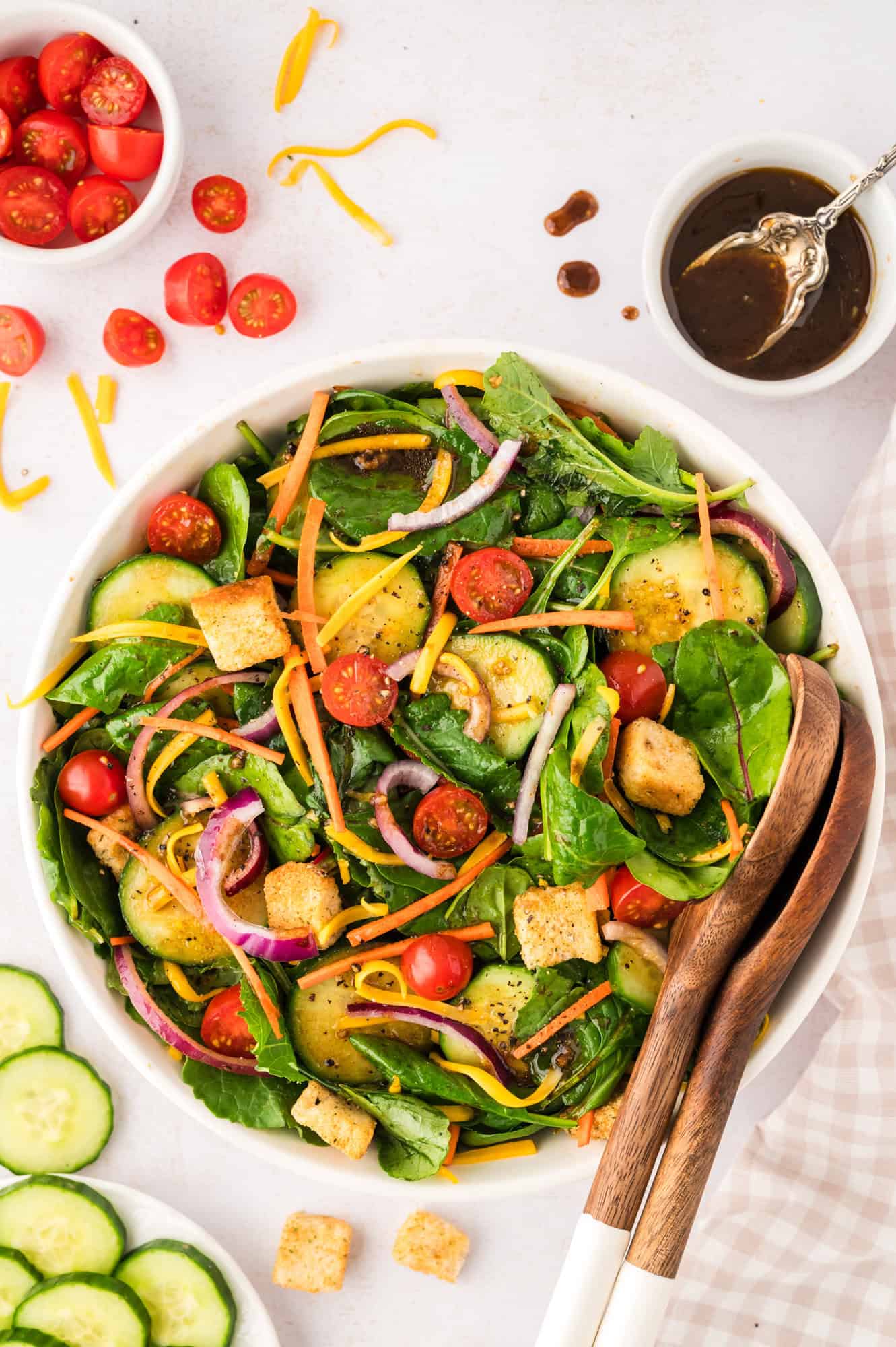 Overhead view of a house salad topped with cheddar cheese and croutons.