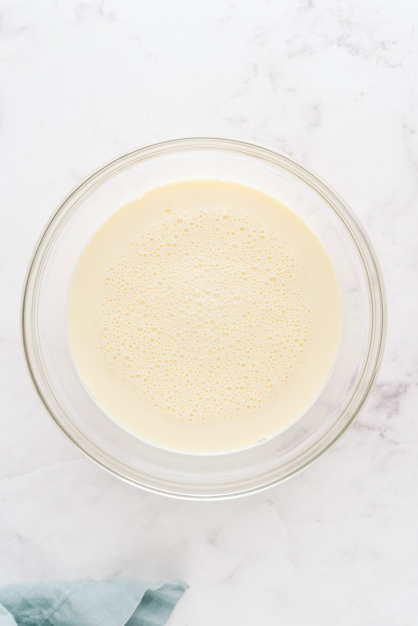 Wet ingredients combined in a large glass mixing bowl.