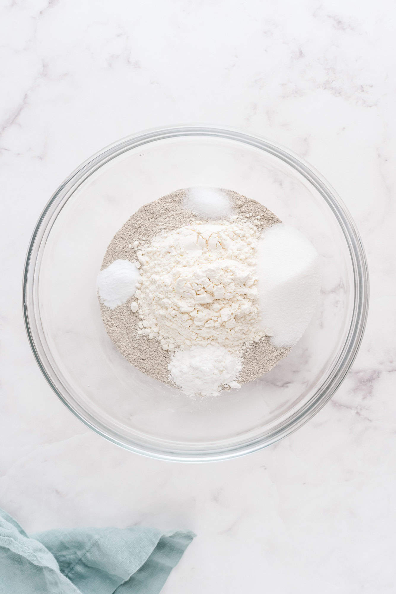 Dry ingredients in a large glass bowl, not yet mixed together.