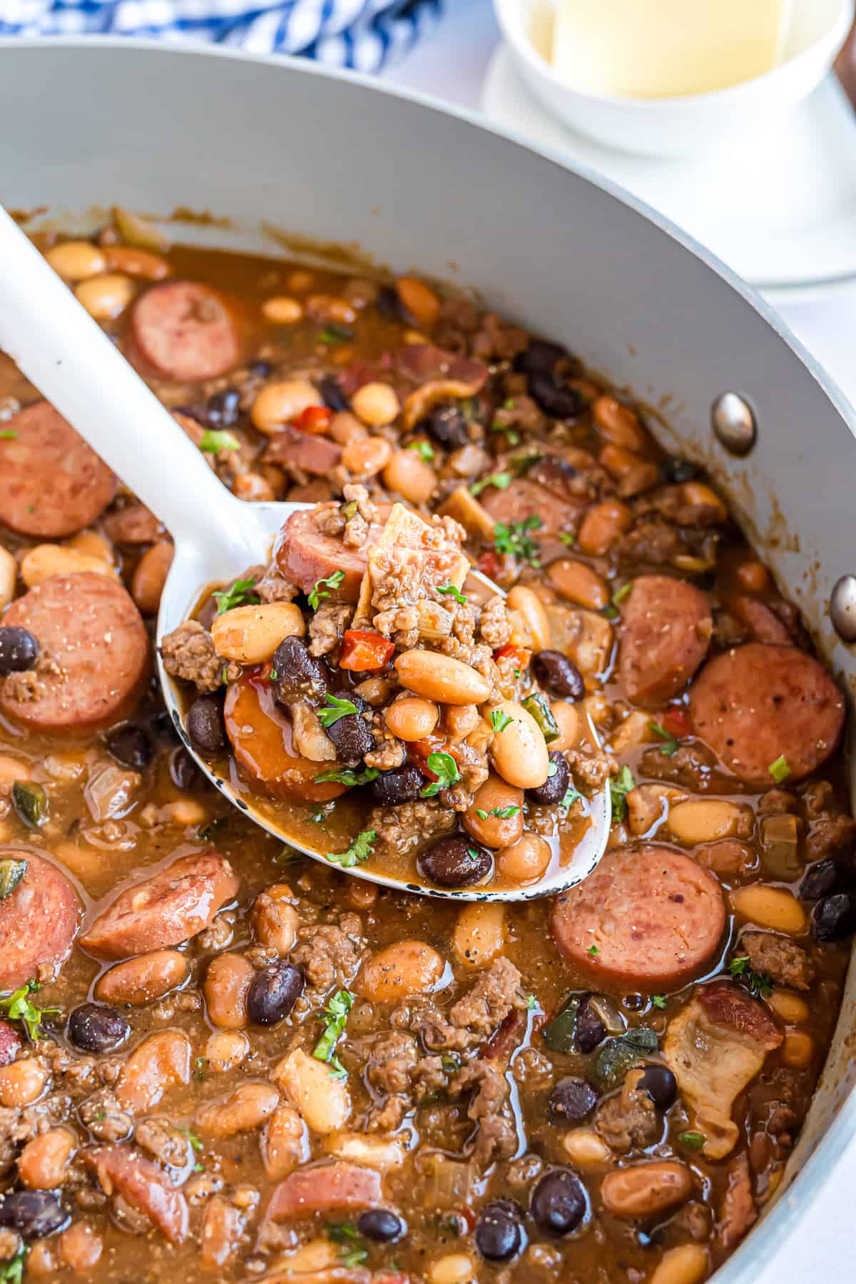 Cowboy beans on a spoon, garnished with parsley.