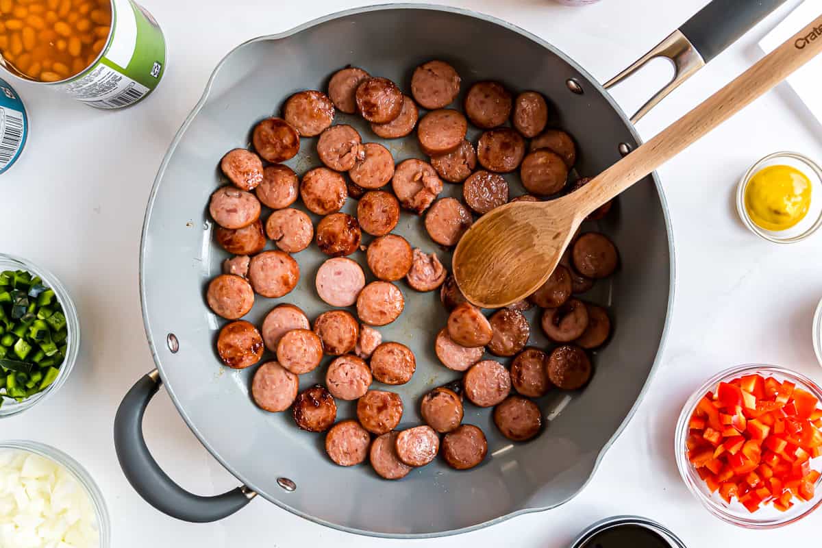 Sliced polish sausage in a frying pan, browned.