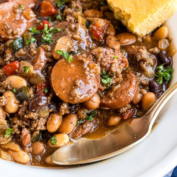 Cowboy beans in a white bowl with cornbread.