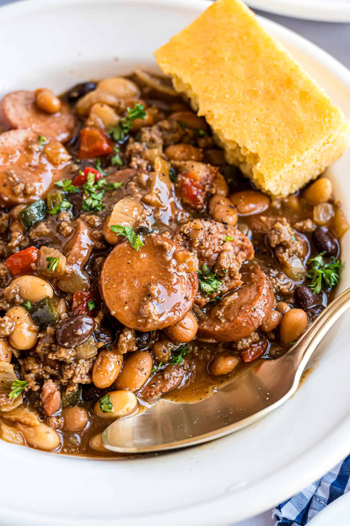 Close up of cowboy beans garnished with a piece of cornbread.