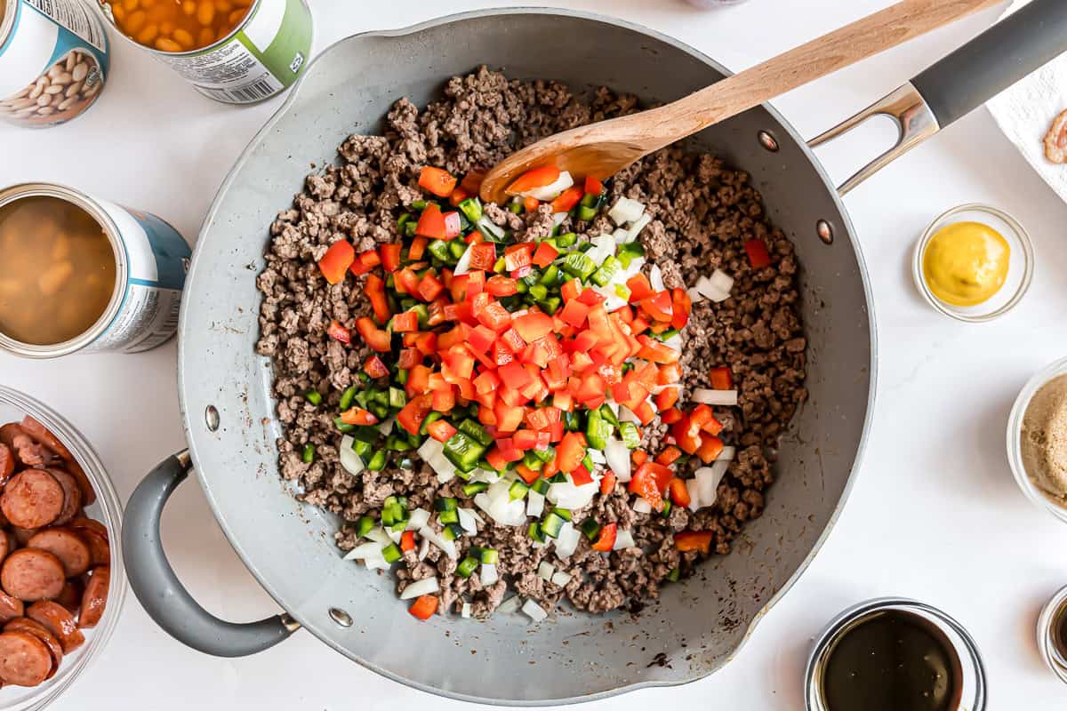 Browned ground beef in a frying pan with vegetables.