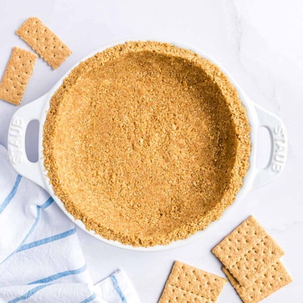 Graham cracker crust in a white pie plate.