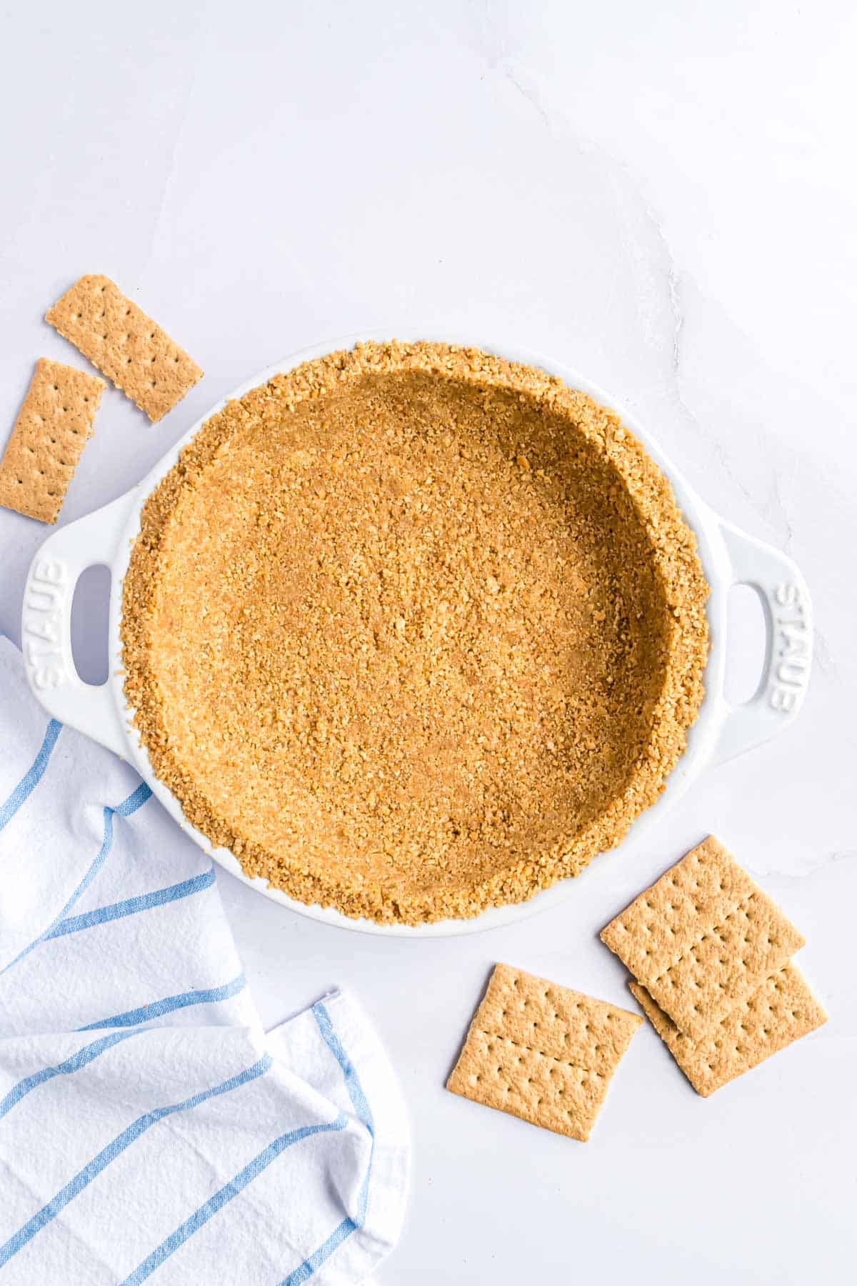 Graham cracker crust in a white pie plate.