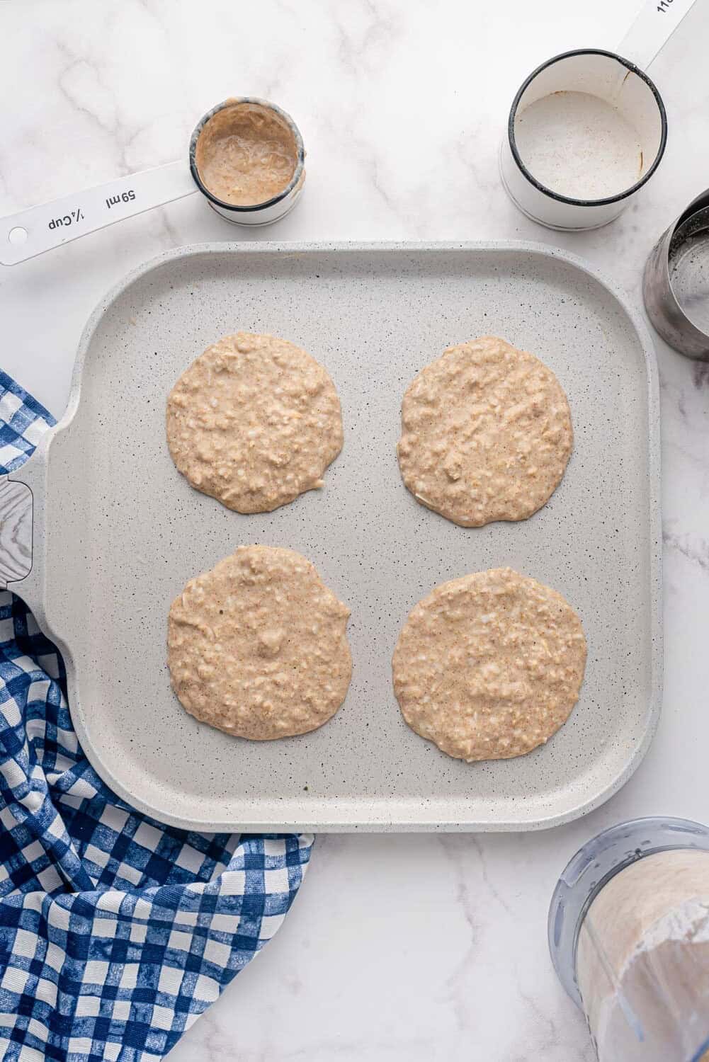 Uncooked pancakes on a griddle.
