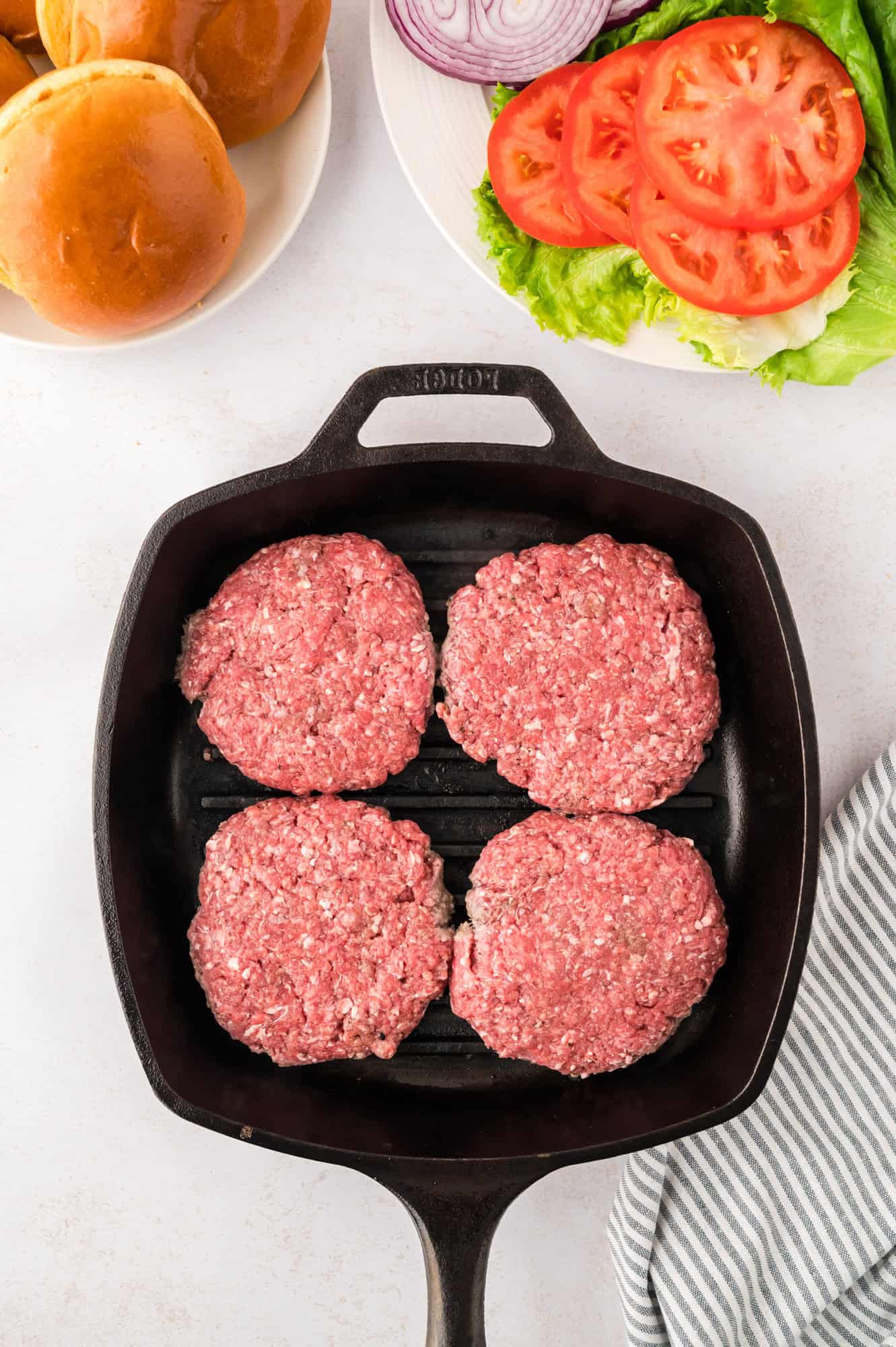 Uncooked burger patties on a grill pan.