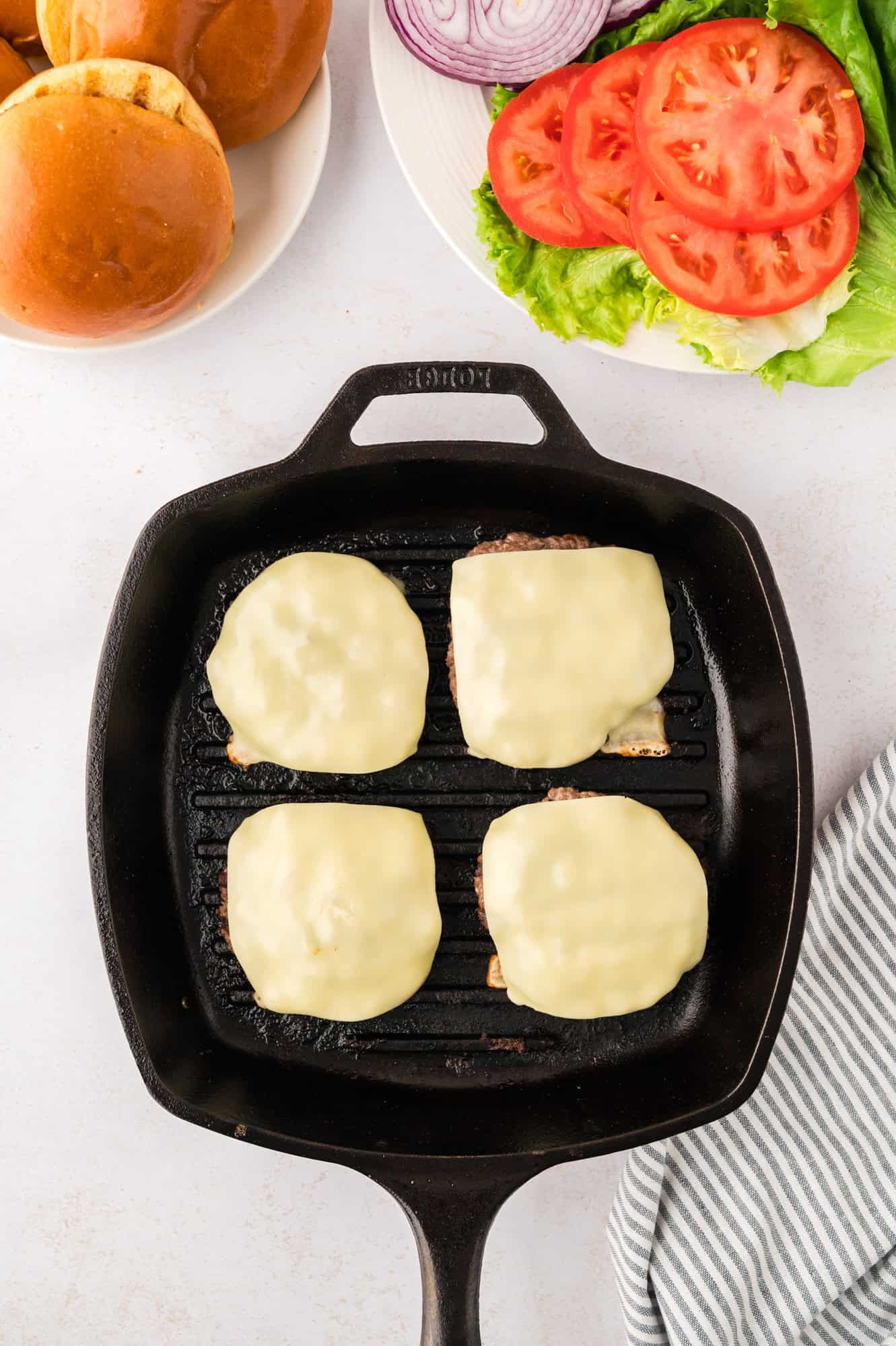 Slices of cheese added to cooked burger patties.