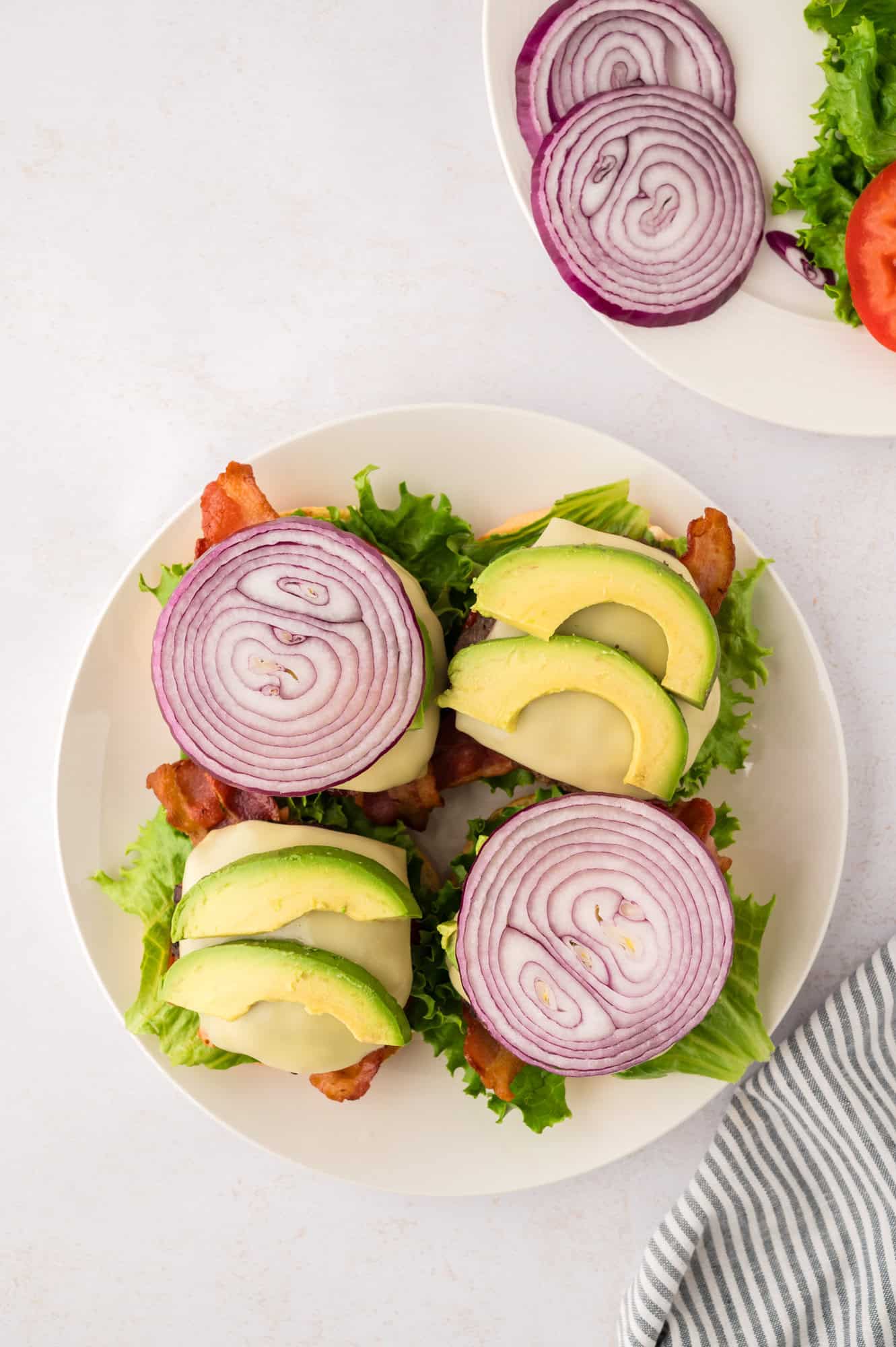 Toppings added to burgers, including onions and avocado.