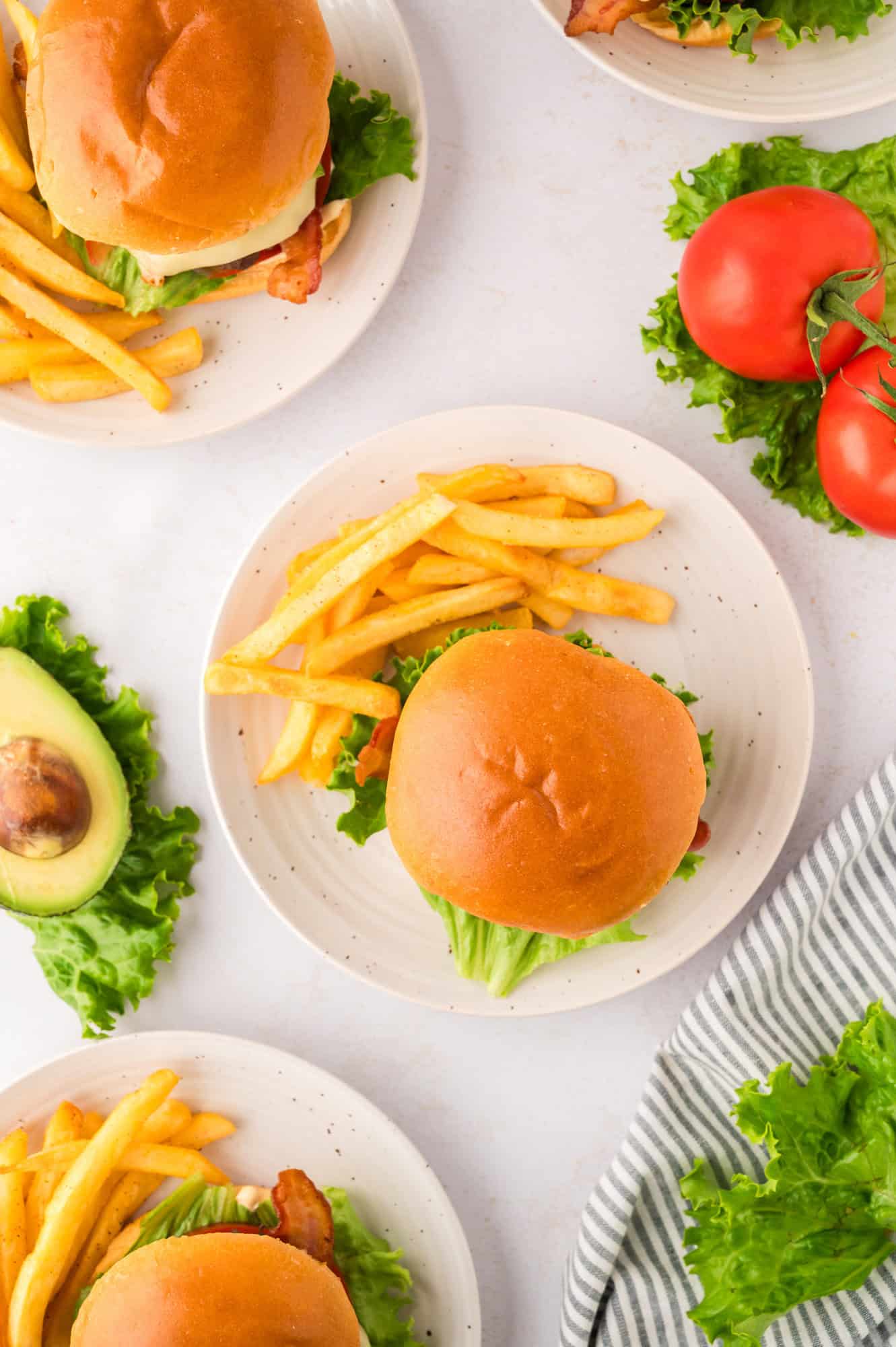 Bun top added, burger plated with fries.