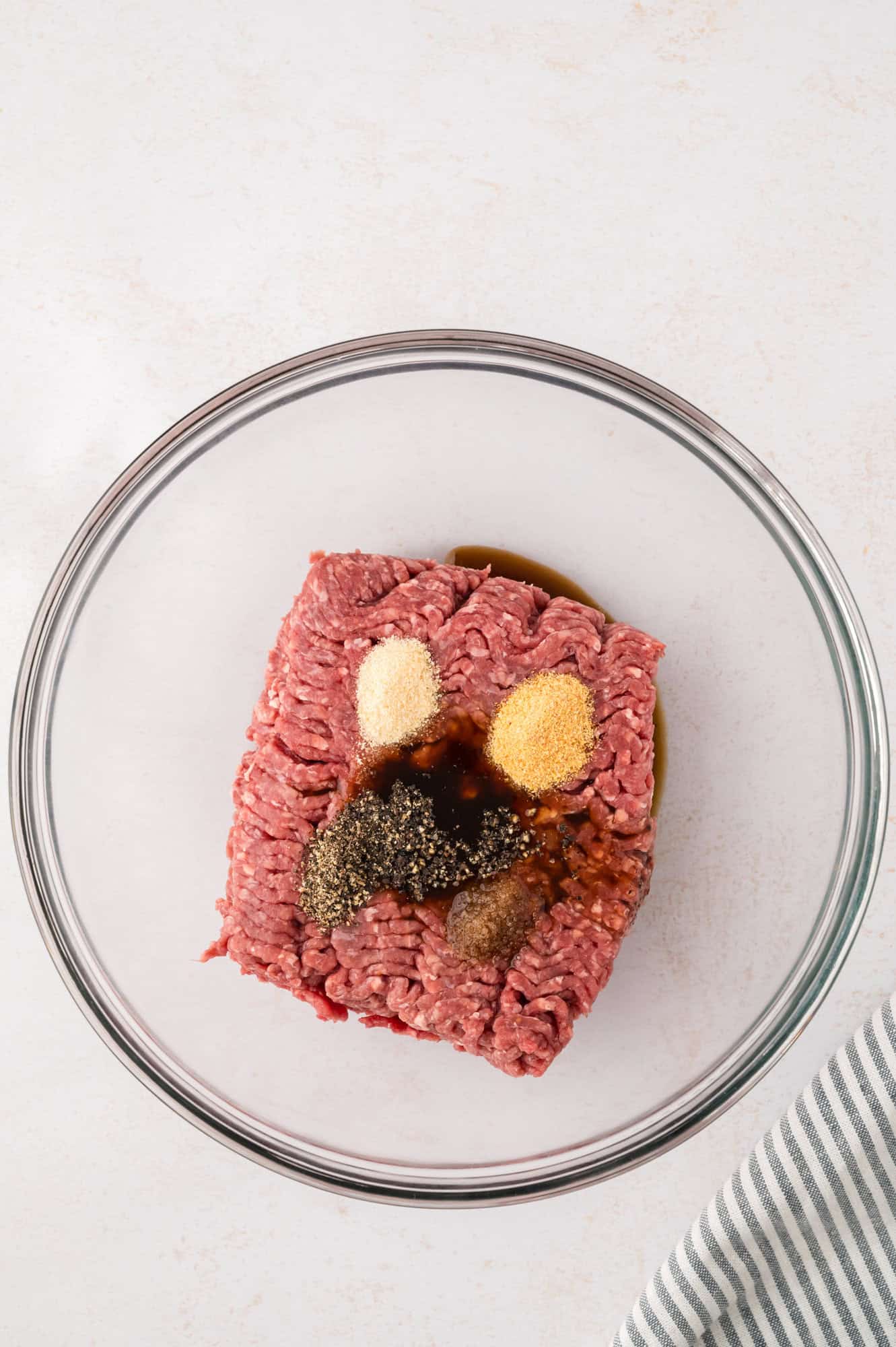 Ground beef, with seasonings on top.