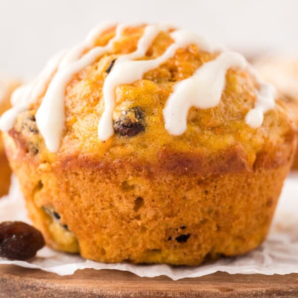 Close up view of carrot cake muffin with cream cheese glaze.