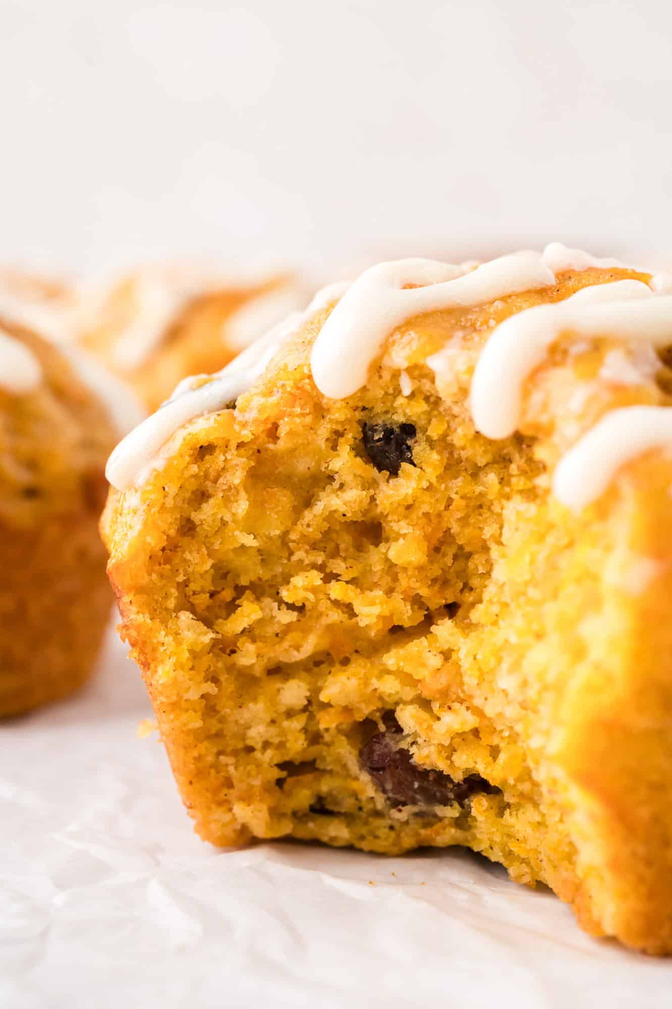 Carrot cake muffin with a large bite removed to show inside texture.
