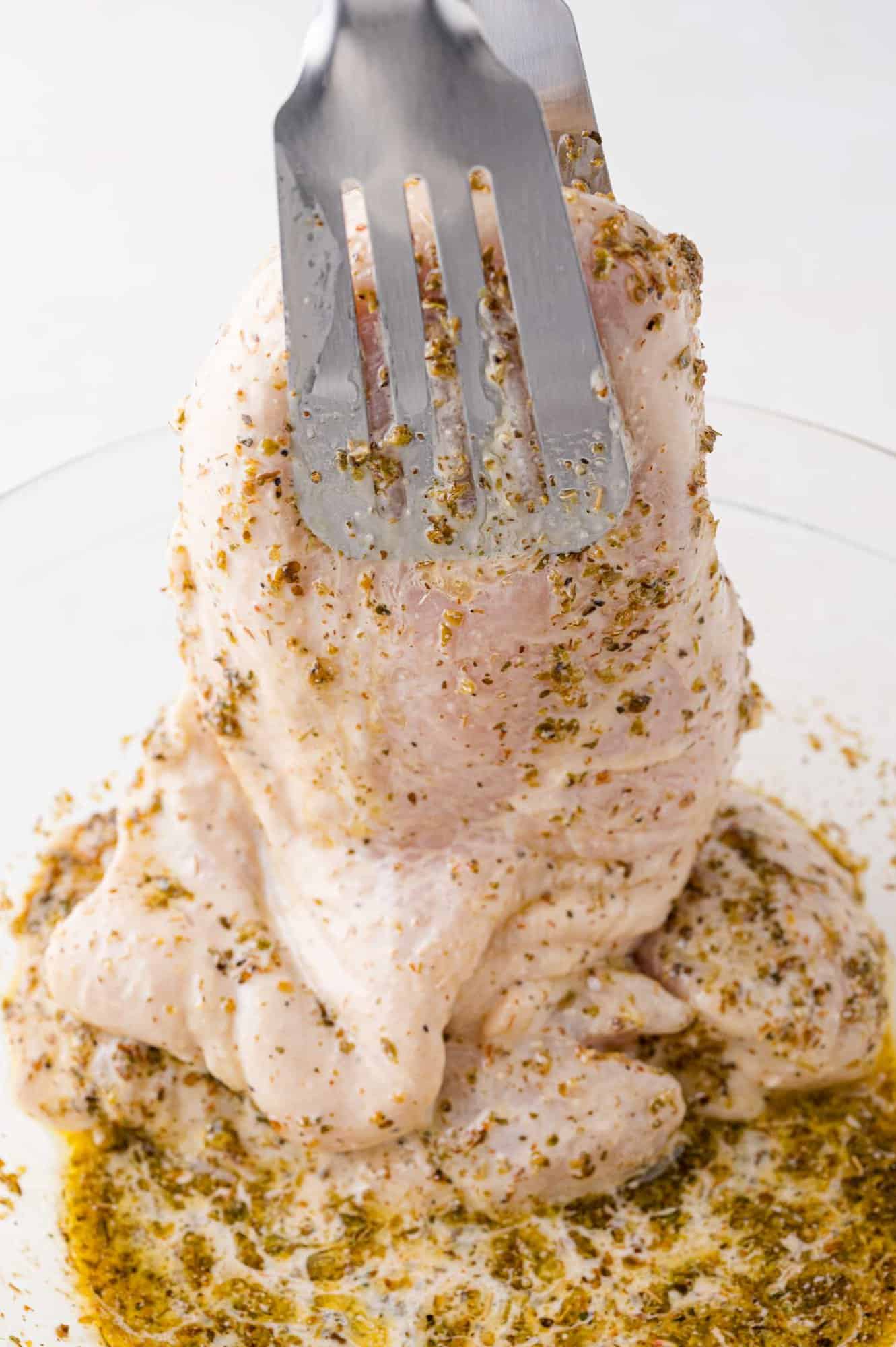 Chicken being removed from marinade.