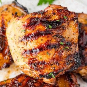 Grilled chicken thigh, sitting on top of others.